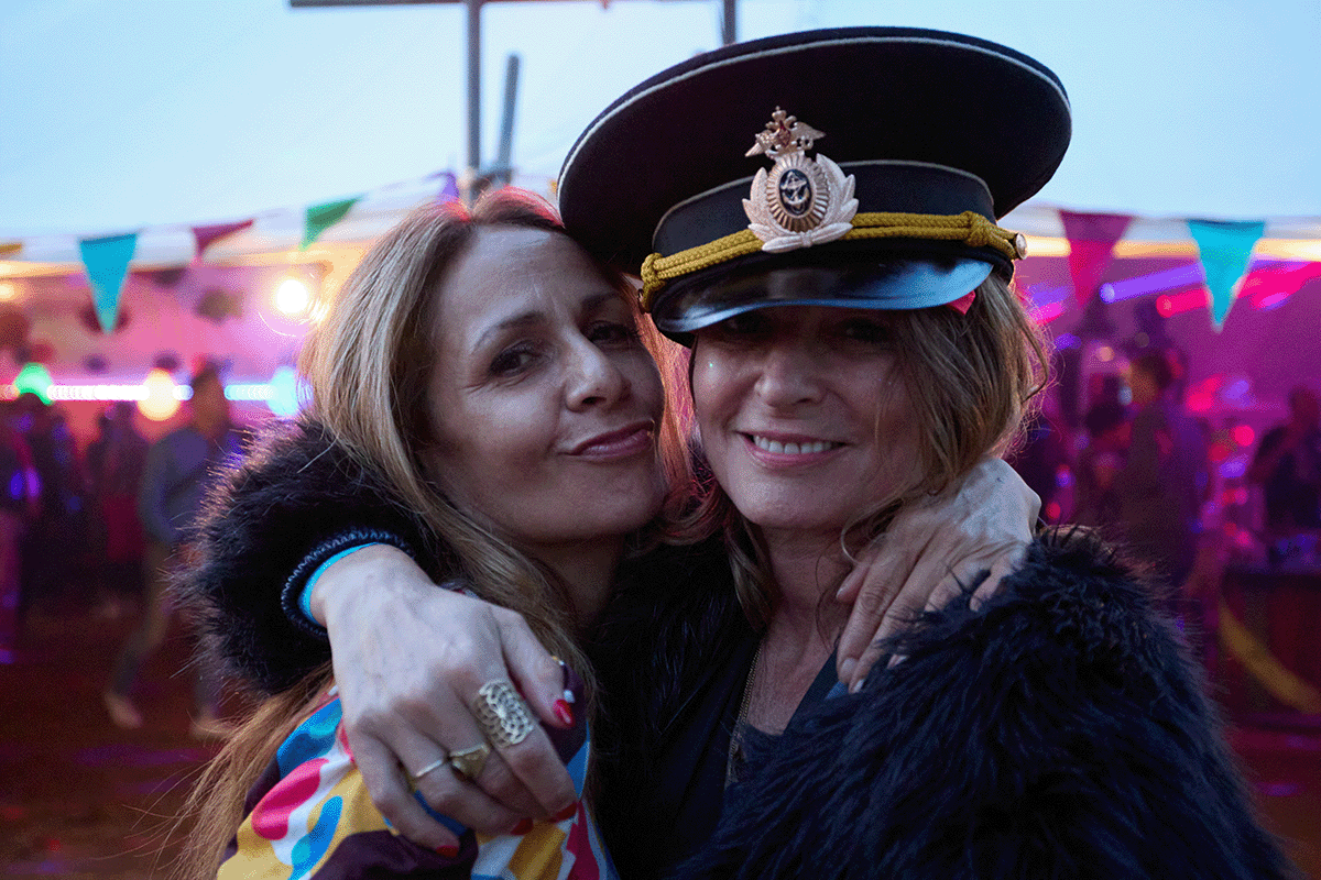 Festivalgoers dancing at Campo Sancho with colourful lights and countryside backdrop at Walkern Hall