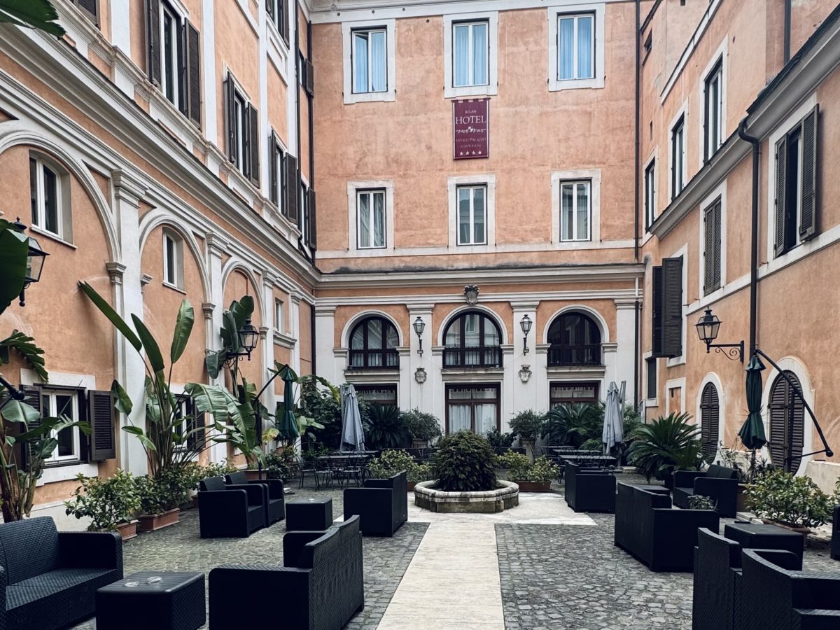 Courtyard at Hotel Antico Palazzo Rospigliosi in central Rome with outdoor seating and historic architecture