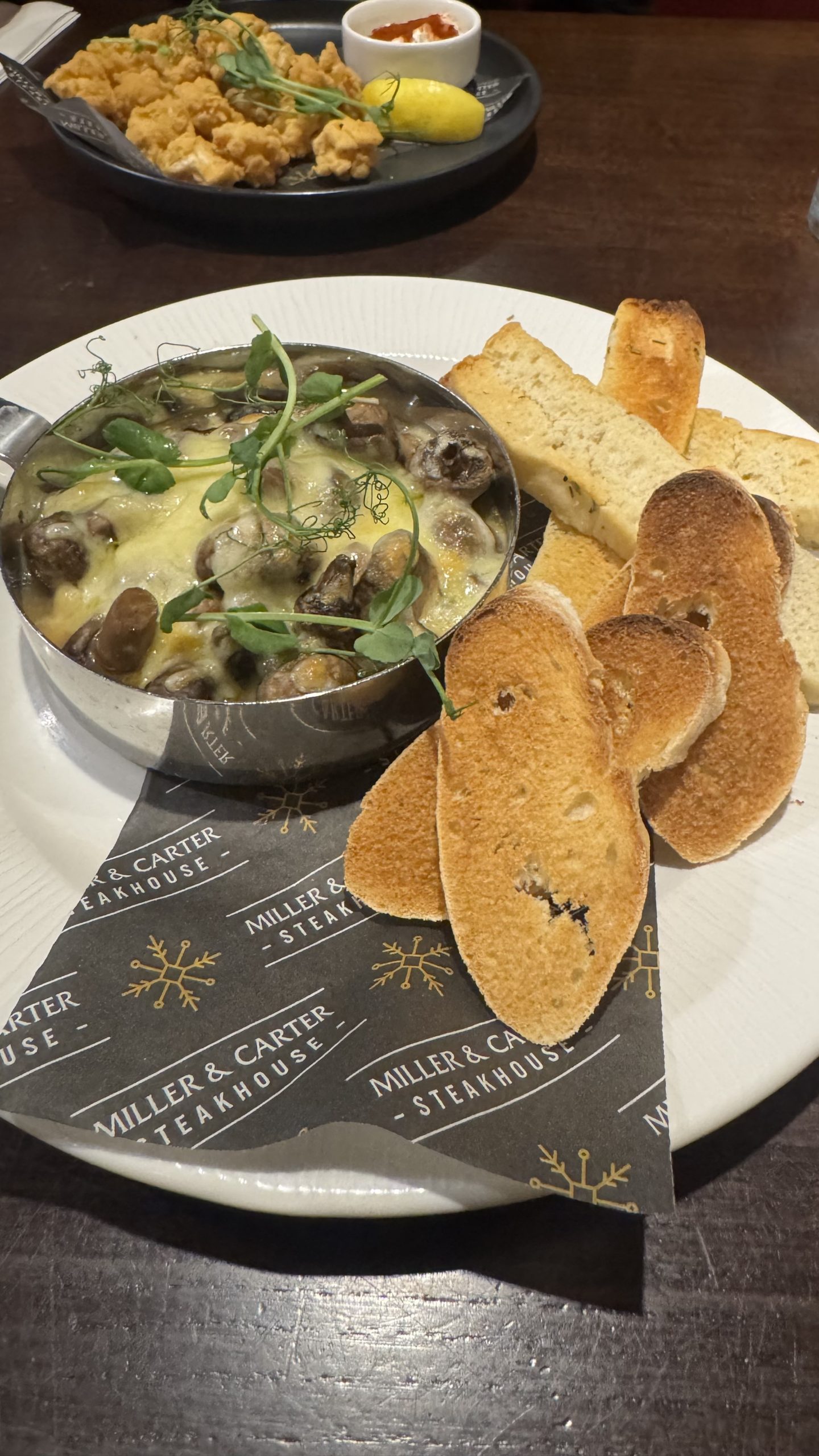 Baked cheddar mushrooms starter at Miller & Carter Reading Description: Baked cheddar mushrooms in a creamy cheddar and spinach sauce with toasted breads at Miller & Carter Reading.